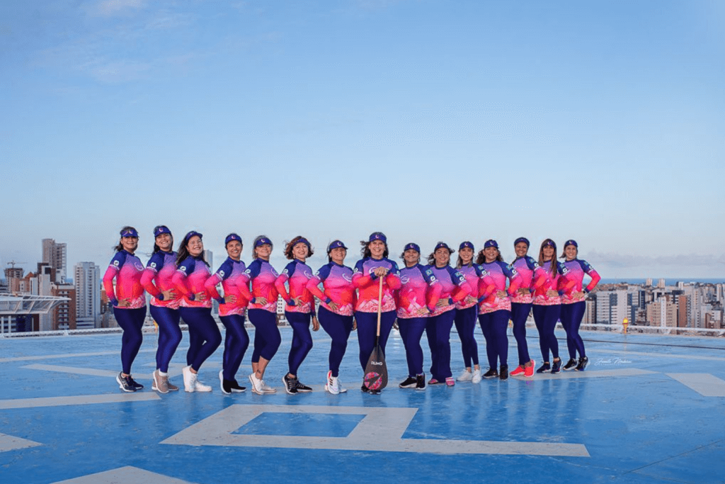 Grupo de participantes da Associação Lua Rosa usando roupas rosas em área externa
