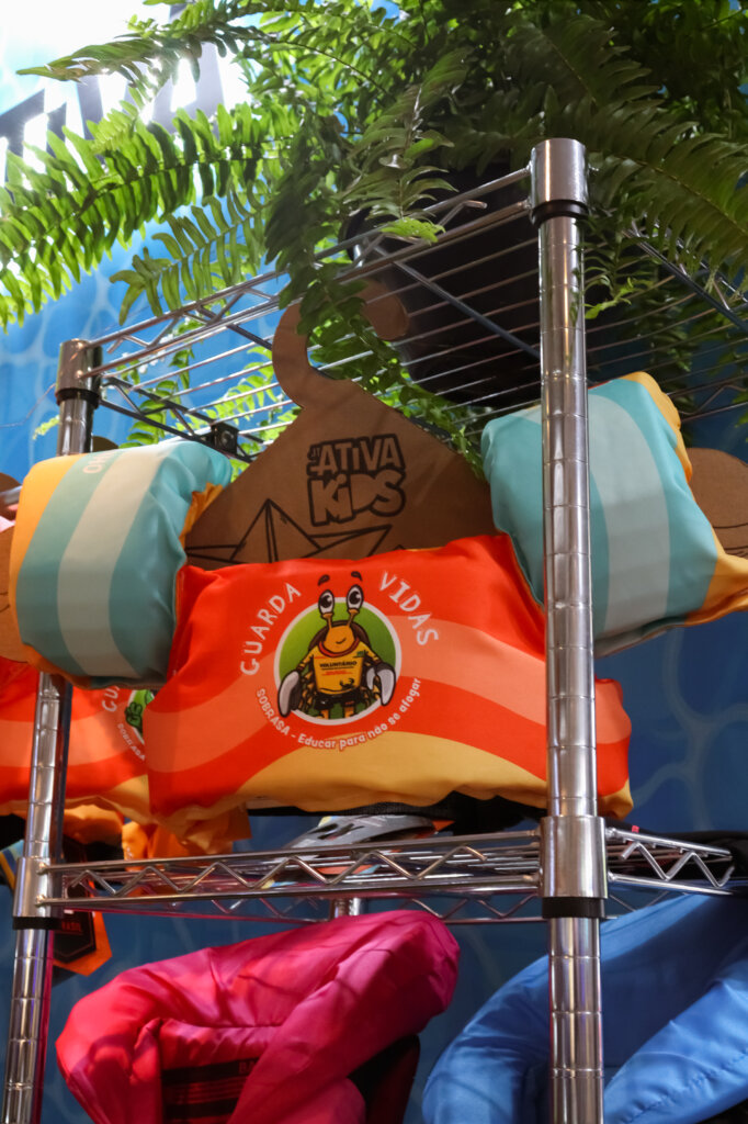 Colete salva-vidas infantil laranja e azul em exposição