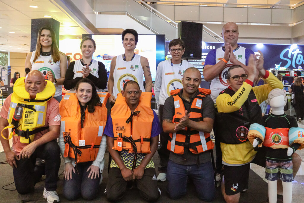 Grupo reunido no Encontro Internacional de Natação com coletes salva-vidas em exposição