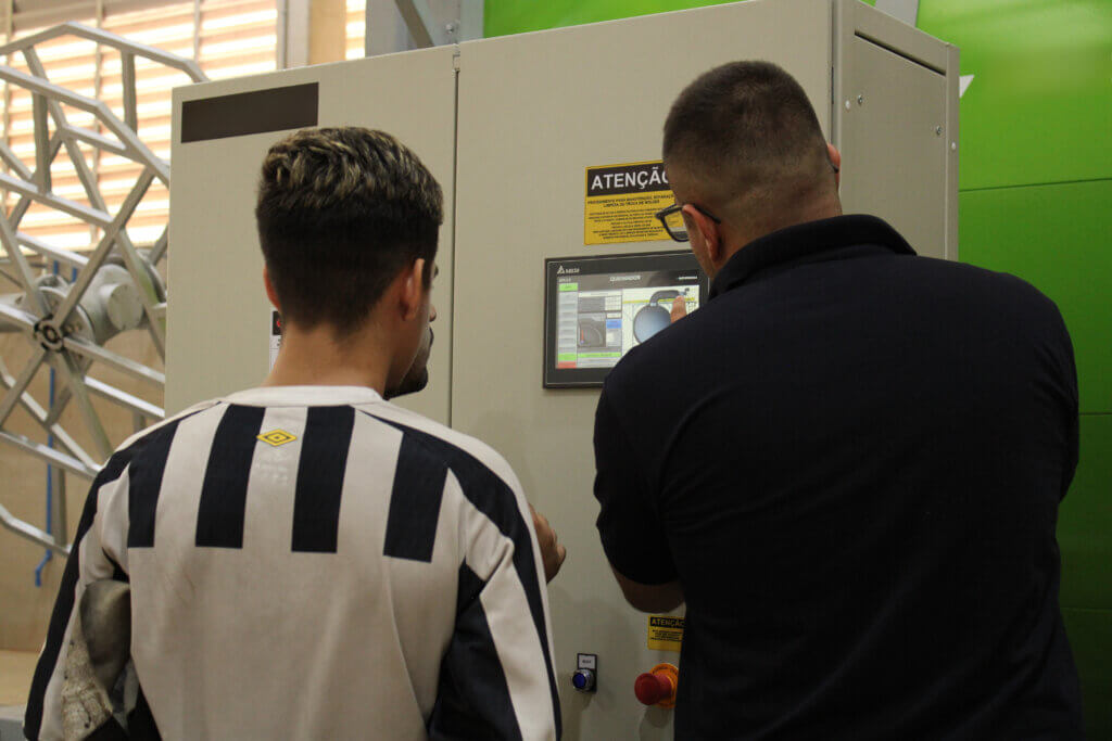Operadores configurando painel de controle do novo maquinário