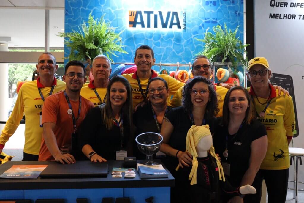 Grupo reunido no espaço da Ativa Náutica com coletes infantis em exposição