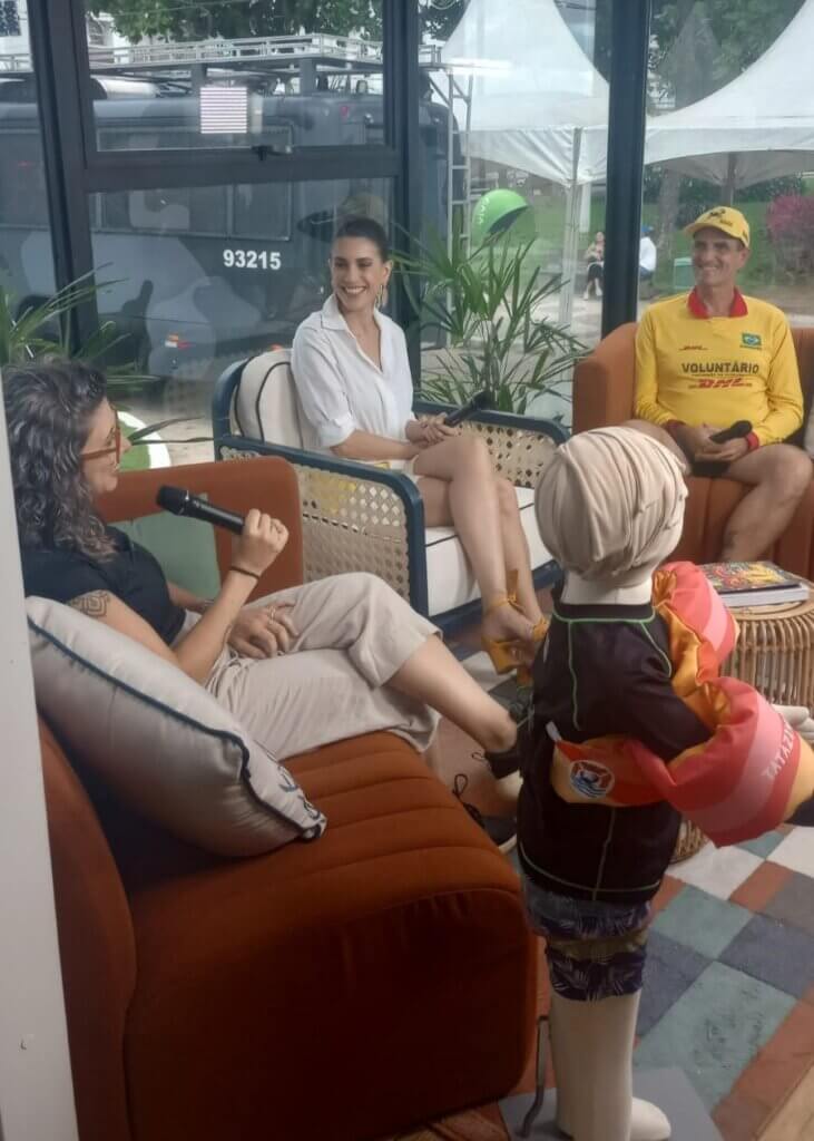 Gravação sobre segurança na água com participantes e manequim usando colete salva-vidas