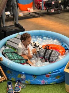 Criança em piscina infantil com produtos náuticos durante evento na Decathlon