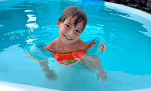 Criança na piscina usando dispositivo de flutuação infantil