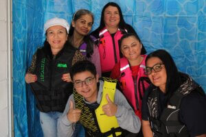 Grupo de participantes usando coletes salva-vidas durante a campanha Wear It 2025