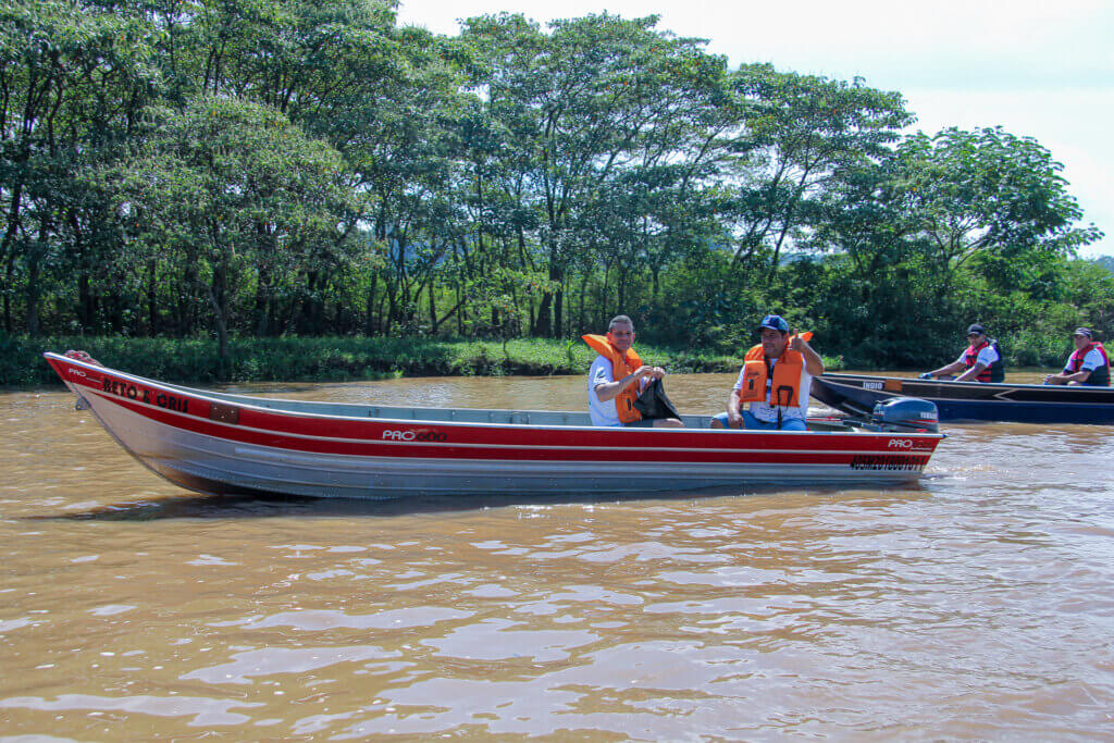 Participantes usando coletes salva-vidas em embarcação no Rio Atibaia
