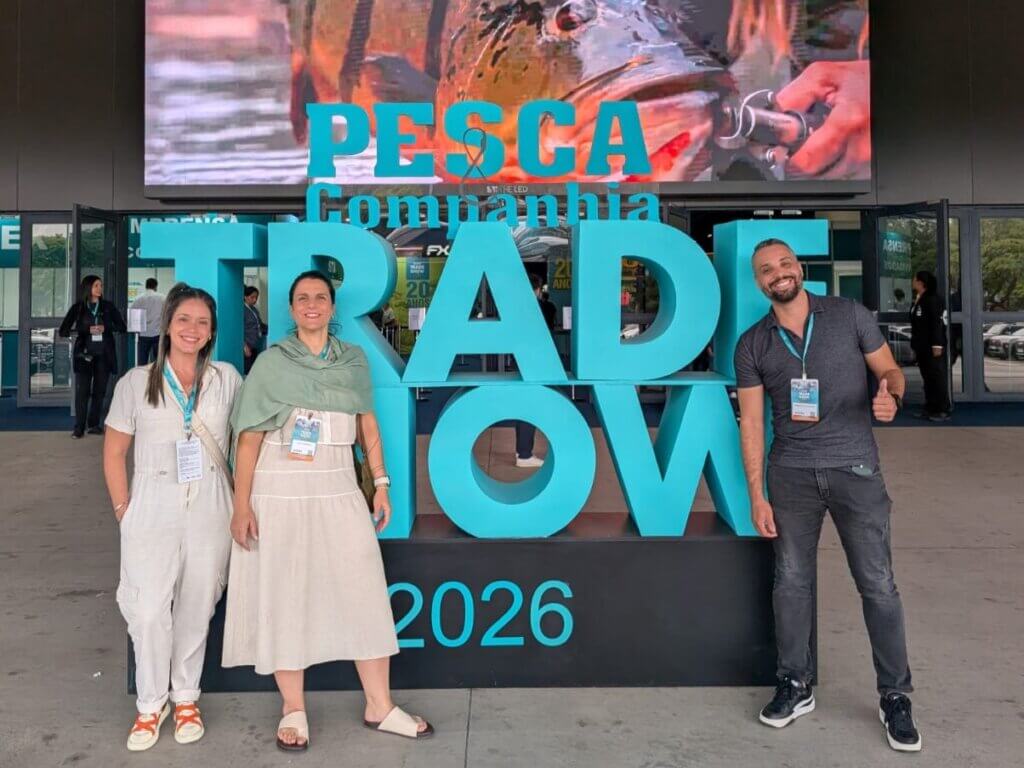 Três participantes em frente à identificação da Pesca Trade Show 2026
