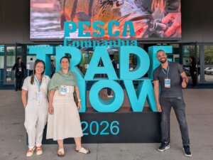 Três participantes em frente à identificação da Pesca Trade Show 2026