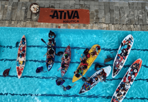 Vista aérea de atividade com caiaques e participantes em piscina
